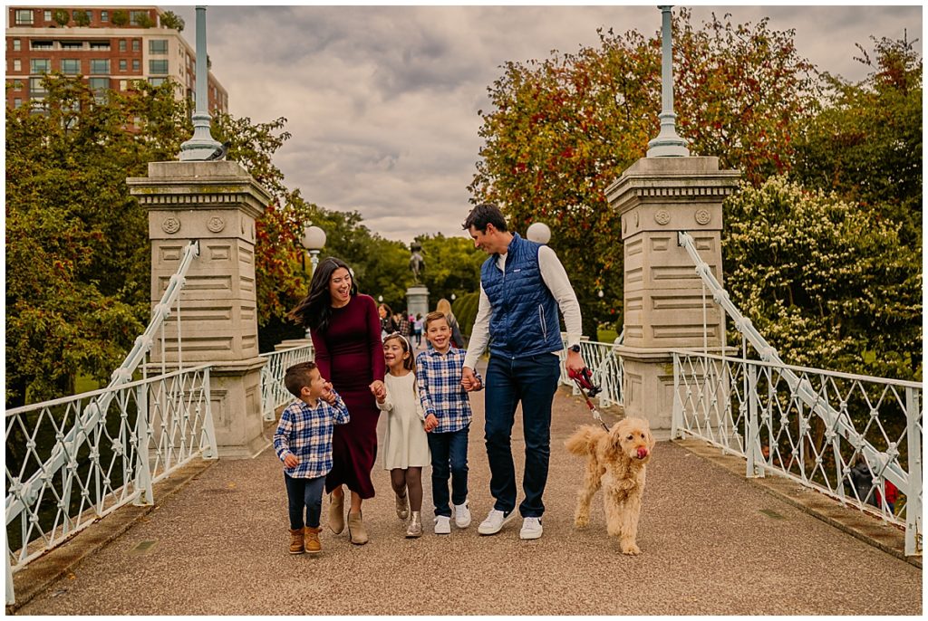 Family walking across bridge with dog