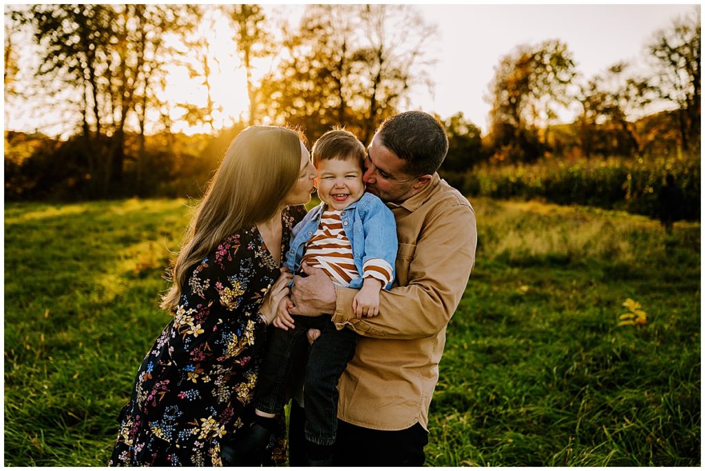 Jen kissing her sons cheek with a golden sun behind her during a Boston family photography session