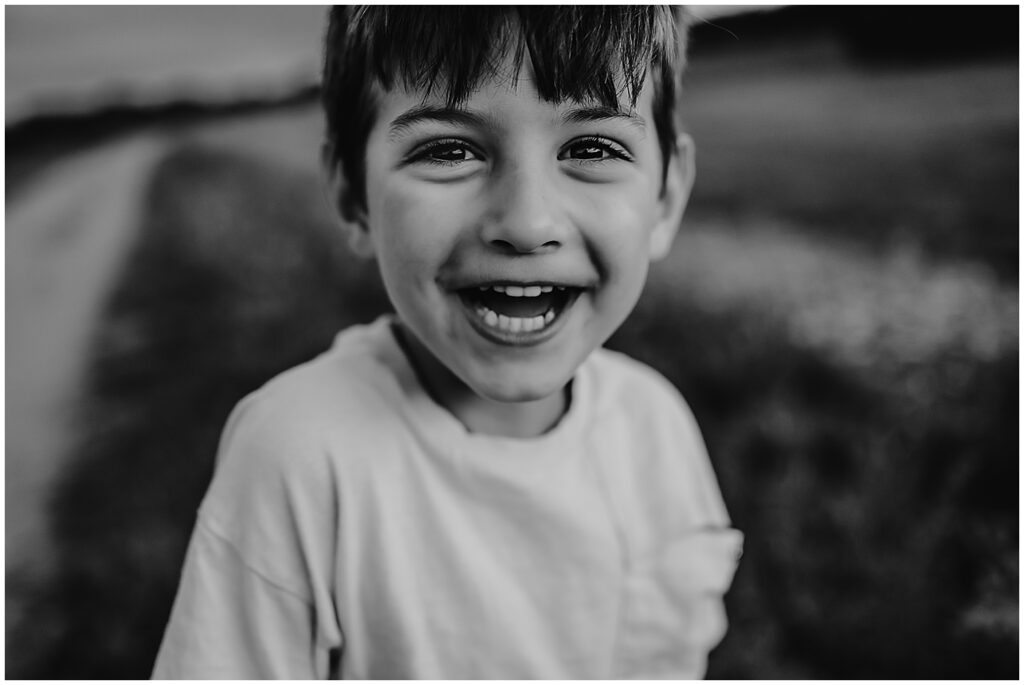 Boy looking at the camera laughing at a joke made my a Boston Family Photographer.  