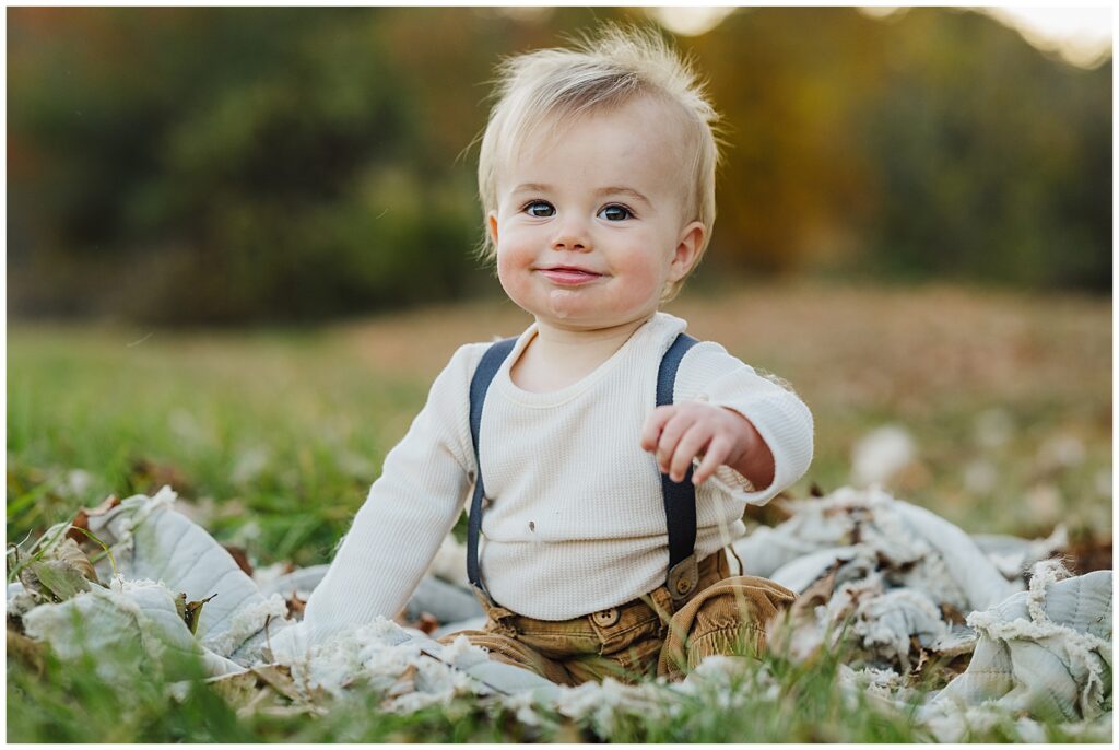 Baby who is drooling sitting in a field of wild flowers during a photography session.